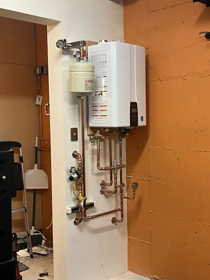 Plumbing technician inspecting water heater connections in Jesup